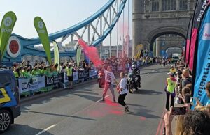 A polícia enfrenta os jovens exigindo manifestantes quando são retirados do caminho da raça de elite na Maratona de Londres. Os manifestantes da demanda para jovens interromperam a raça de elite masculina na Maratona de Londres