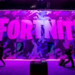 Attendees walk past signage for Epic Games Inc.'s Fortnite