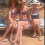 O ano de 61 anos, Trinny Woodall (L), parecia brilhante quando encontrou um pino em seu biquíni azul sem tiras junto com membros da família Ingrid e Victoria Jacobson