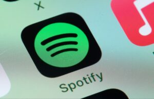 A Apple aprovou uma atualização para o aplicativo Spotify que nos permitirá que os usuários acessem informações sobre preços e links de pagamento externos Spotify, Apple Music on smart phone screen.