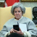 White House chief of staff Susie Wiles looks at her phone as US President Donald Trump speaks in the Oval Office of the White House