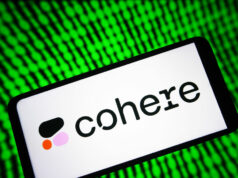 O ano de US$ 240 milhões da Cohere prepara o terreno para o IPO Image of a phone with Cohere's logo on it with a green digital background.
