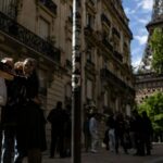 Três pedestres tiram uma selfie no beco pitoresco no final da Rue de L'Höxesite, Paris