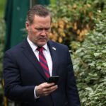 O consultor de segurança nacional Michael Waltz olha para o telefone enquanto se prepara para uma entrevista na TV na Casa Branca na quinta -feira imediatamente antes de disparar