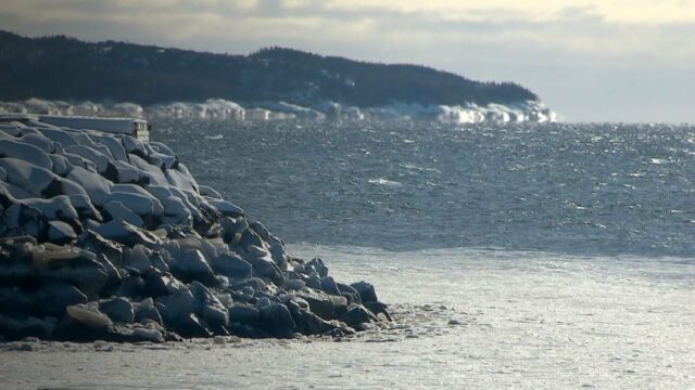 Berca de água larga e algumas pedras cobertas de neve no golfe de St. Lawrence.