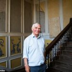 Francis 'F *****' Fulford está de pé em uma grande escada grande na câmara tão cavernica porque é sombria