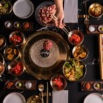 O co -fundador da empresa, Jay Shin, abre a porta lateral do caminhão de churrasco e frutos do mar coreano da OLHSO em Foster City, Califórnia, na sexta -feira, 26 de julho de 2024. Este é um novo modelo de serviço de entrega de refeições, no qual os alimentos são totalmente cozidos autônomos por um computador enquanto fornecem ao cliente refeições cozidas frescas de uma maneira oportuna. (Jose Carlos Fajardo/Bay Area News Group)