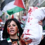 Uma mulher detém um adereço que representa uma bolsa para o corpo porque manifestantes pró-palestinos participam de um protesto, no dia da grande final do concurso de músicas do Eurovision em Basileia 2025