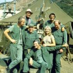 Loretta Swit na foto acima cercada por seus membros do elenco M*S*H*, da esquerda: Mike Farrell, William Christopher, Harry Morgan, Alan Alda, Jamie Farr e David Ogden Stiers