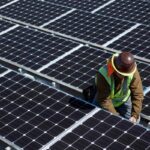 A man inspects solar panels.