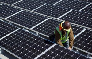 A Microsoft compra mais um 100 MW de energia solar, desta vez no Japão A man inspects solar panels.