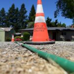 Rick Hempy, residente do Remen Tract, fica na frente de sua casa na terça -feira, 6 de maio de 2025, em Pleasanton, Califórnia. Hempy está fornecendo água por meio de uma mangueira de jardim para um vizinho depois que uma linha de água quebrou no bairro Remen Tract de Pleasanton. (Aric Crabb/Bay Area News Group)