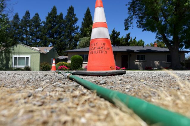 Rick Hempy, residente do Remen Tract, fica na frente de sua casa na terça -feira, 6 de maio de 2025, em Pleasanton, Califórnia. Hempy está fornecendo água por meio de uma mangueira de jardim para um vizinho depois que uma linha de água quebrou no bairro Remen Tract de Pleasanton. (Aric Crabb/Bay Area News Group)