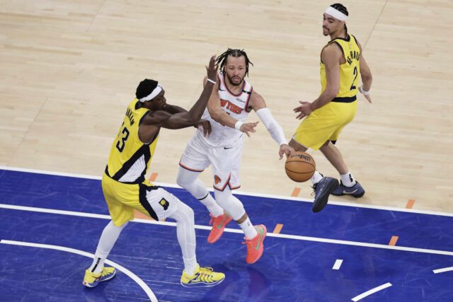 O guarda do New York Knicks, Jalen Brunson (11), a final da Conferência Leste do Basquete da NBA em Nova York, o quarto trimestre da final da Conferência Leste de Basquete da NBA de 29 de maio de 2025, passa a bola contra Pascal Siakam (43) e o Watchman Andrew Nembhard (2).