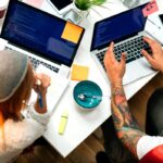 Two people at laptops, coding