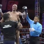 O árbitro Smaylin Valdez levanta as mãos de Norbelto Jiménez antes de entrar em torno dos fãs e perdedores dentro do círculo no centro olímpico Juan Pablo Duarte em Santo Domingo na República Dominicana de sábado