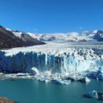 Os turistas observam como um enorme pedaço de gelo quebra a geleira argentina