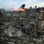 As pessoas andam entre as ruínas no local de um acidente de avião pessoal perto da vila de Grabovo na Ucrânia em 17 de julho de 2014