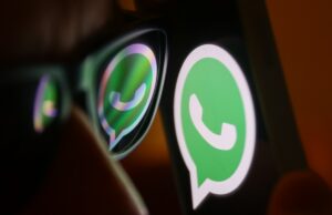 Whatsapp agora tem mais de três bilhões de usuários mensais WhatsApp logo reflected on sunglasses and displayed on a phone screen.