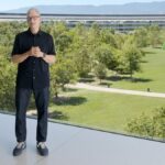 Tim Cook com um fone de ouvido atrás de um computador