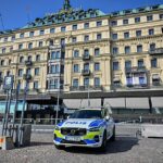 Um veículo policial sueco está estacionado do lado de fora do Grand Hotel durante a reunião de Bilderberg em Estocolmo