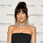 Dakota Johnson sopra Chris Martin no concerto italiano