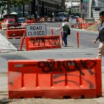 Um ciclista acontece na segunda -feira, 16 de junho de 2025, em Oakland, Califórnia, através do cruzamento de Thomas L Berkeley Way e Webster Street. O trabalho é realizado para criar caminhos de pedestres e bicicletas da estação da 19th Street Bart até Lake Merritt. (Aric Crabb/Bay Area News Group)