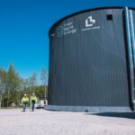 Two technicians walk by the Pornainen sand battery.