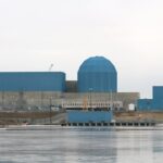 The Clinton Clean Energy Center stands before a frozen lake.