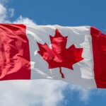 Canada flag waving against a blue sky
