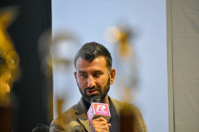 O Cheteshwar Pujara pede a Michael Vaughan que assine o tweet de previsão emoldurado entre o troféu de Border-Gavascar de 2020-21 (relógio).

