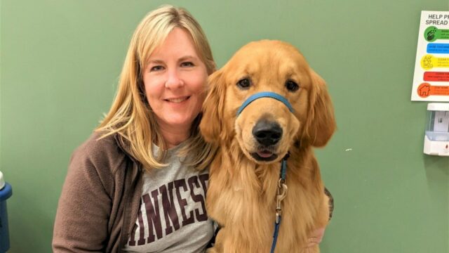 Melissa Hortman senta -se ao lado de um Golden Retriever.