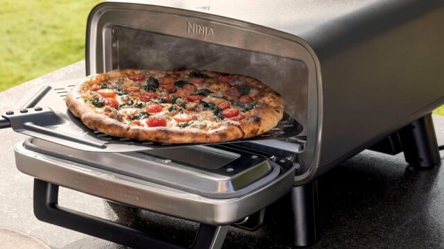 Uma pizza está localizada em um pino de um deck do lado de fora
