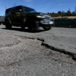 Na quinta -feira, 2 de março de 2023, um ciclista está entregando um grande buraco no Park Boulevard entre a Highway 13 e a St. James Drive em Oakland, Califórnia.