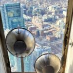 Uma máquina de medição de qualidade do ar montada na torre CN, com vista para o horizonte da cidade.
