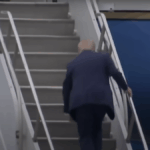 Um homem tropeça enquanto ele caminha pelas escadas de um avião.