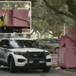 Carros da polícia perto da cesta de doações rosa.