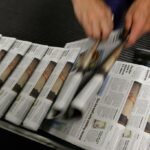 A photo of a stream of newspapers on the printing press.