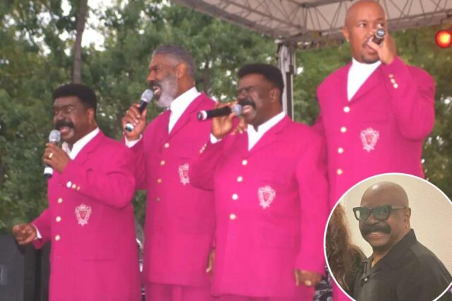 Quatro homens em ternos rosa combinando cantando em microfones.