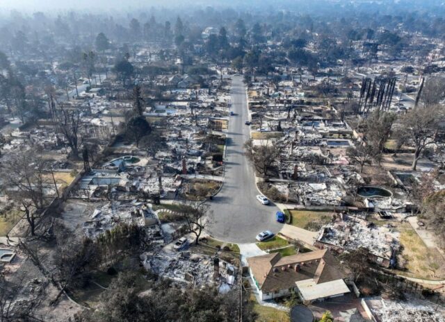 Um bombeiro tenta extinguir chamas em um prédio residencial em chamas durante o Eaton Fire em 8 de janeiro de 2025 em Altadena, Califórnia (AP Photo/Chris Pizzello, arquivo)