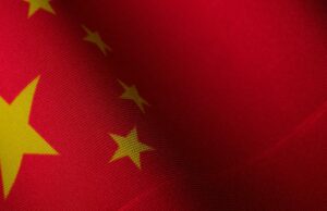 A Apple lida com o novo problema antitruste na China sobre as políticas da Application Shop Cinco aplicativos VPN na App Store tinham conexões com militares chineses | Close up de uma bandeira chinesa