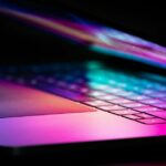Aqui estão os oito níveis de segurança da Apple que protegem seus dados | MacBook parcialmente aberto com reflexões coloridas