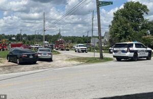 Dois adoradores são mortos a tiros quando o atirador leva carnificina para a igreja depois de ferir a polícia no aeroporto de grama azul de Kentucky As tropas estaduais foram gravemente feridas em um tiroteio em um aeroporto maior antes que o homem da arma fugisse para uma igreja (rua fora da foto) durante o culto de domingo