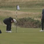 O presidente Donald Trump pode ser visto pegando sua bola no verde depois de uma tacada fracassada