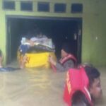 Evacuação policial dos moradores afetados pelo transbordamento do rio Ciliwung em Kebon Pala