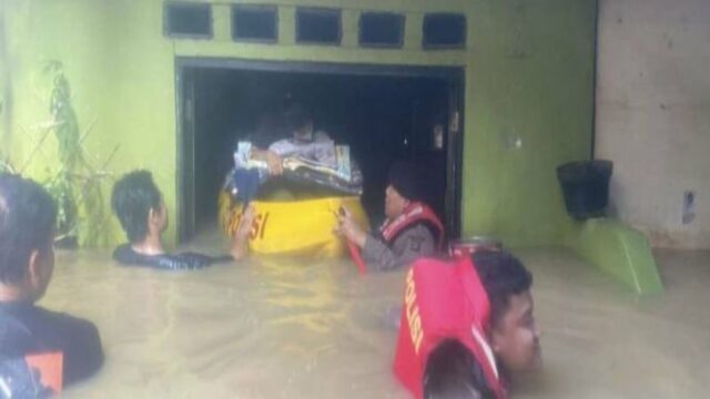 Evacuação policial dos moradores afetados pelo transbordamento do rio Ciliwung em Kebon Pala

