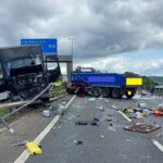 Um veículo com mercadorias pesadas fica na diagonal na reserva central depois de colidir com vários elevadores