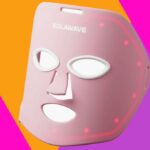 Máscara facial rosa Solawave com luzes LED vermelhas.