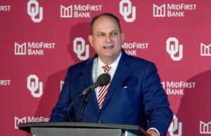Joe Castiglione Backup Search é filmado enquanto gira o antigo trabalho de Oklahoma HC em favor da UFL March Madness Logo