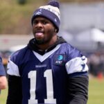 Jones ouve enquanto os fãs cantam "Pay Micah!" no acampamento